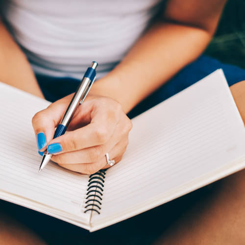 Women sitting down and writing in her journal